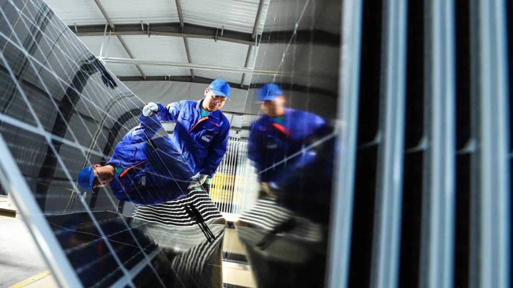 عمال صينيون يتفقدون ألواح الطاقة الكهروضوئية