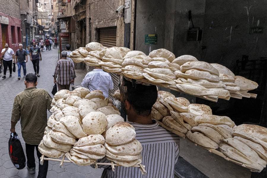 رجل يمشي في شوارع القاهرة ويحمل الخبز