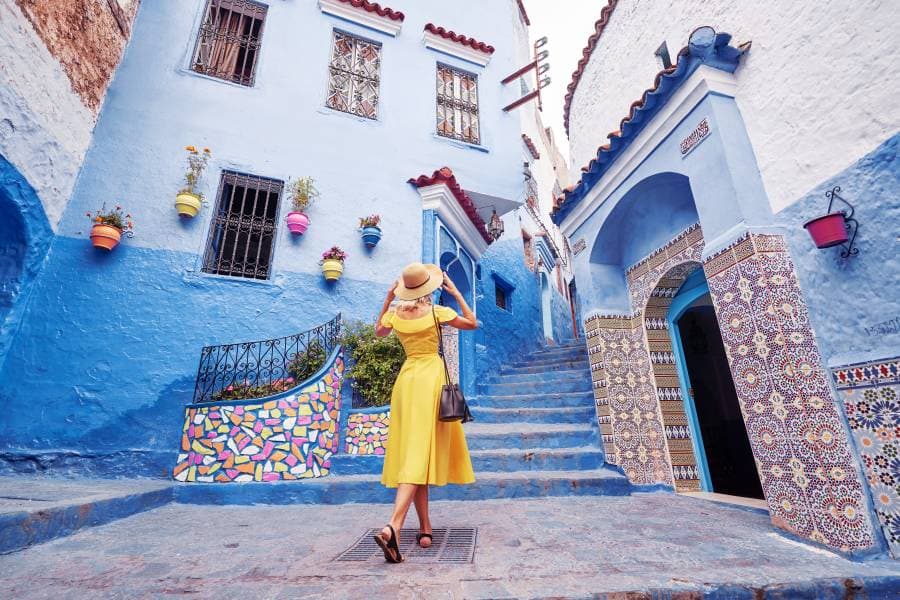 سيدة تتأمل مباني مدينة شفشاون المغربية زرقاء اللون