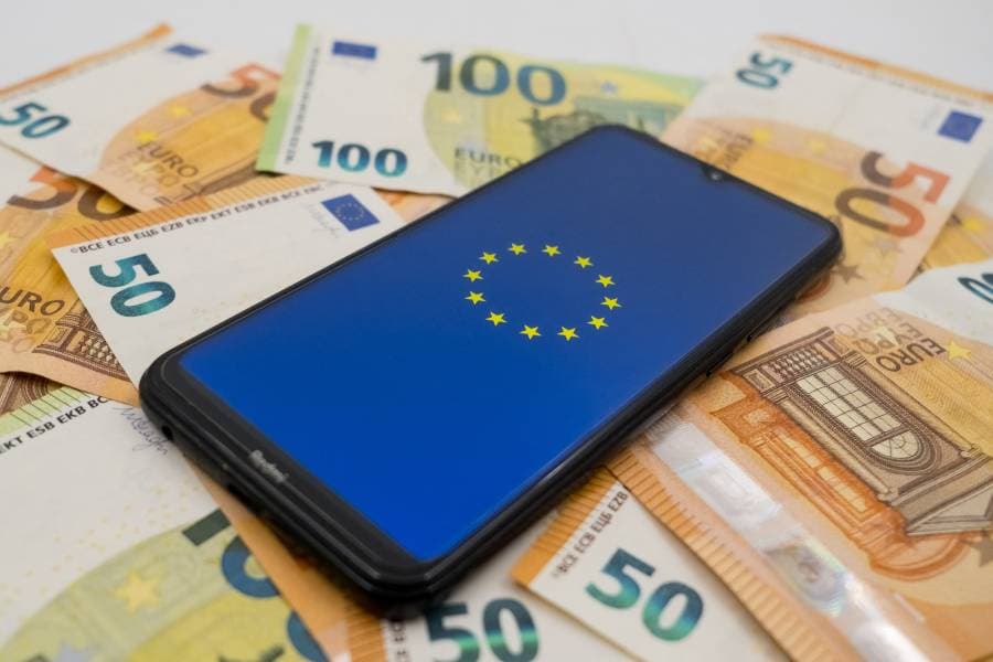 شعار الاتحاد الأوروبي معروضاً على شاشة الهاتف الذكي على أوراق اليورو النقدية في إشارة لإصدار اليورو الرقمي