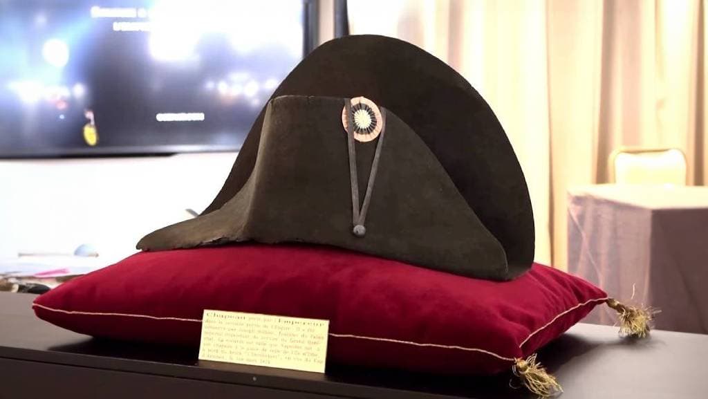 صورة تُظهر قبعة نابليون موضوعة على وسادة من القطيفة الحمراء