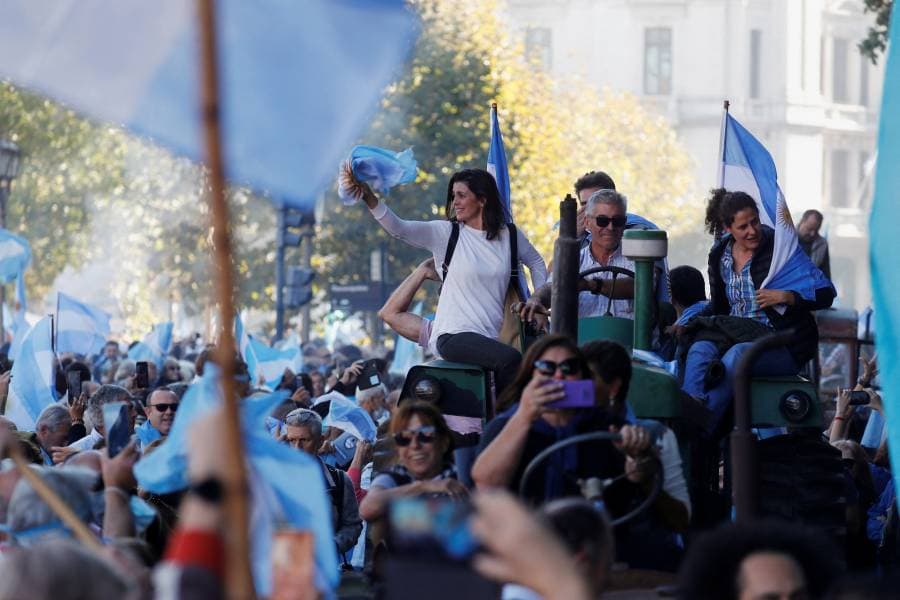 المتظاهرون يرفعون العلم الأرجنتيني خلال احتجاجهم على إجراءات حكومية
