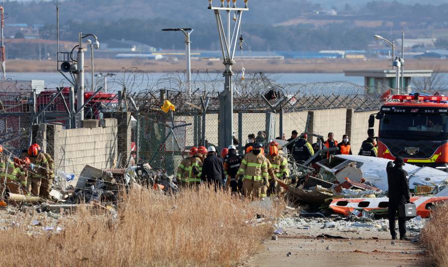 يعمل أفراد الإنقاذ في مكان الحادث الذي تحطمت فيه طائرة تابعة لشركة طيران جيجو من طراز بوينغ 737-800 